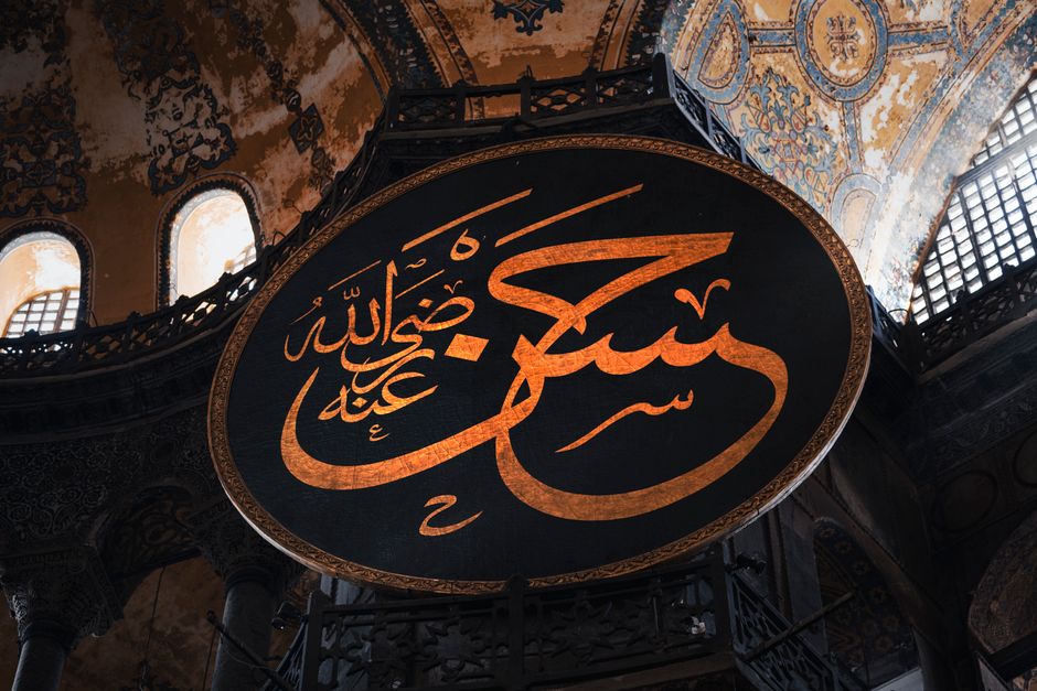 A close-up view of ornate Arabic calligraphy in Istanbul's historic Hagia Sophia, showcasing Islamic architecture.